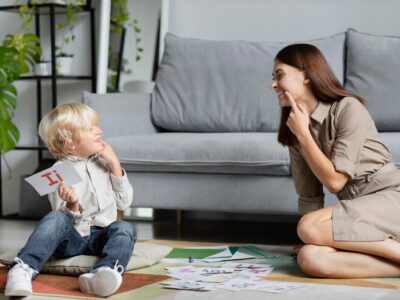 Young woman doing speech therapy with a little boy