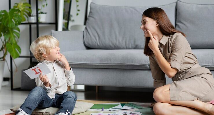 Young woman doing speech therapy with a little boy