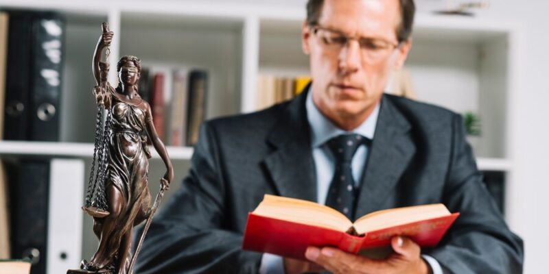 close-up-mature-male-judge-reading-documents-desk-courtroom