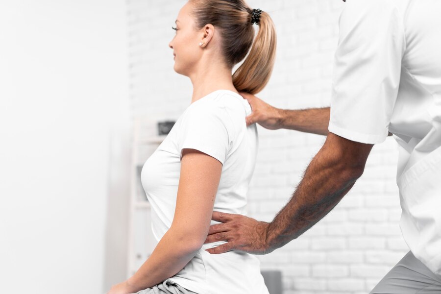 Male physiotherapist checking woman's back